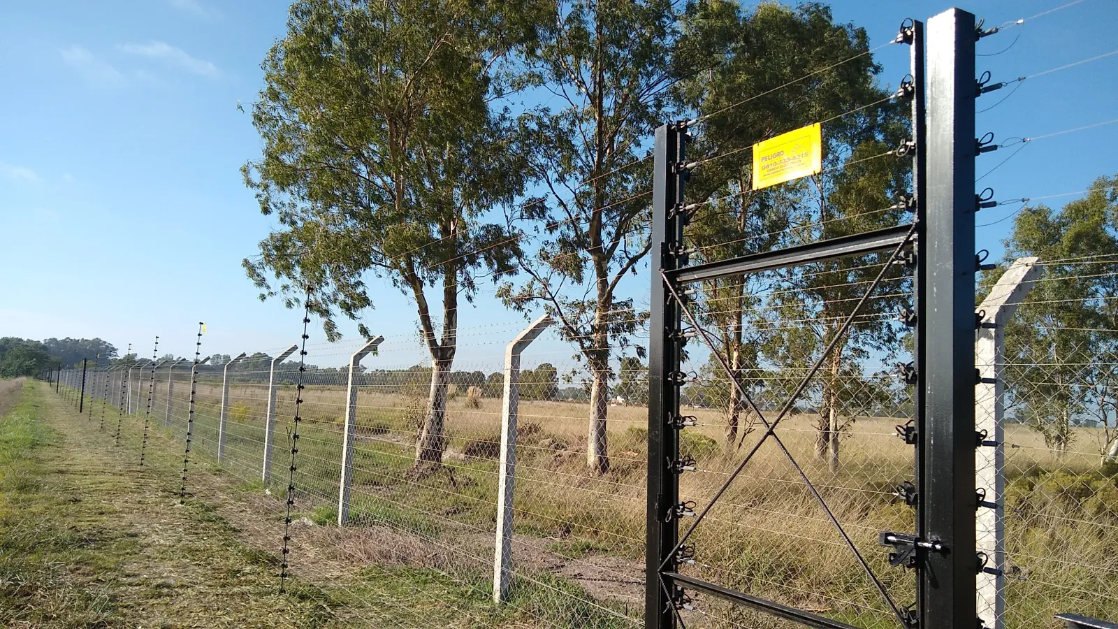 Cerco eléctrico perimetral cubriendo el frente de un predio de gran extensión