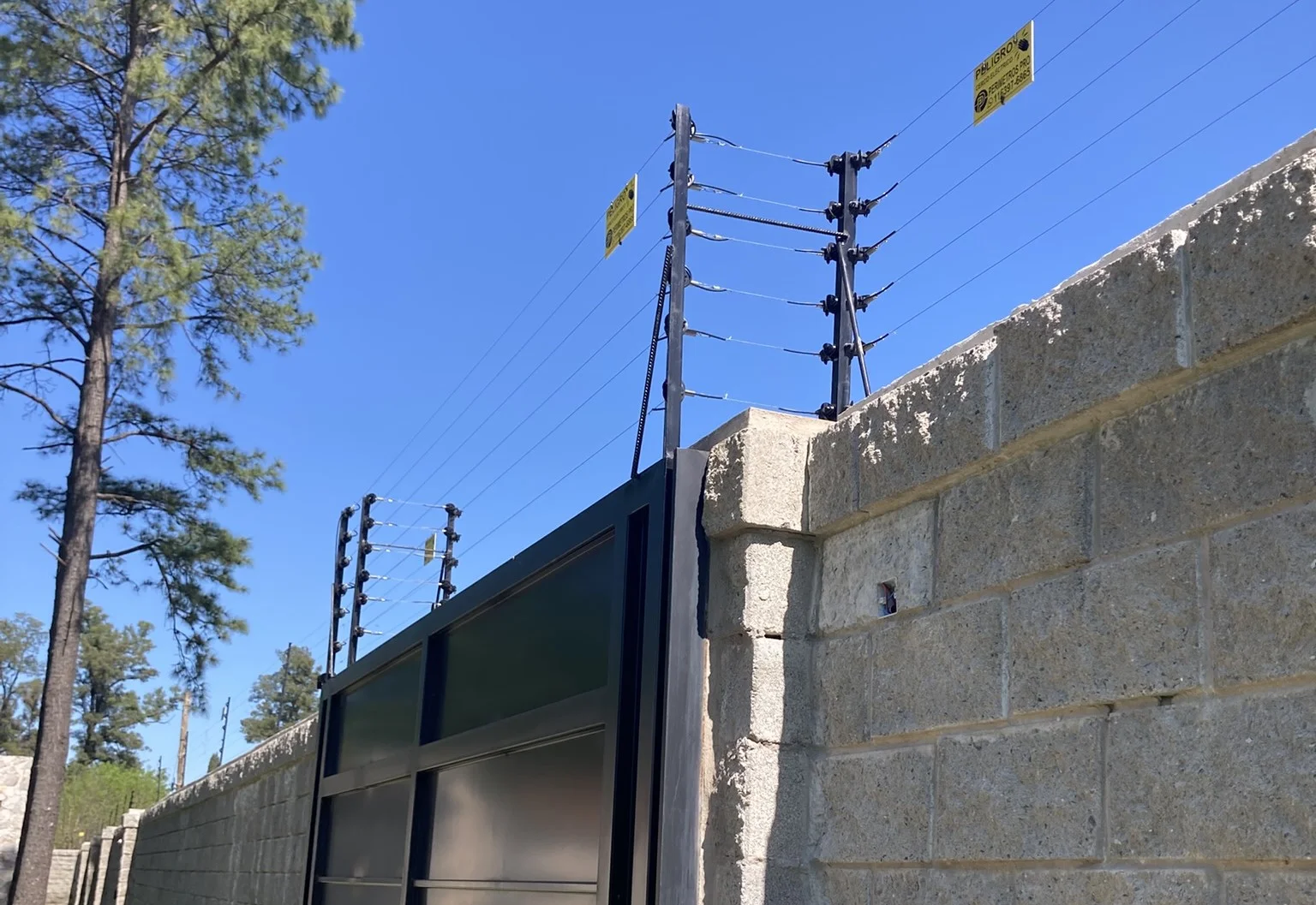 Cerco eléctrico autoportante sobre muro y portón de un predio