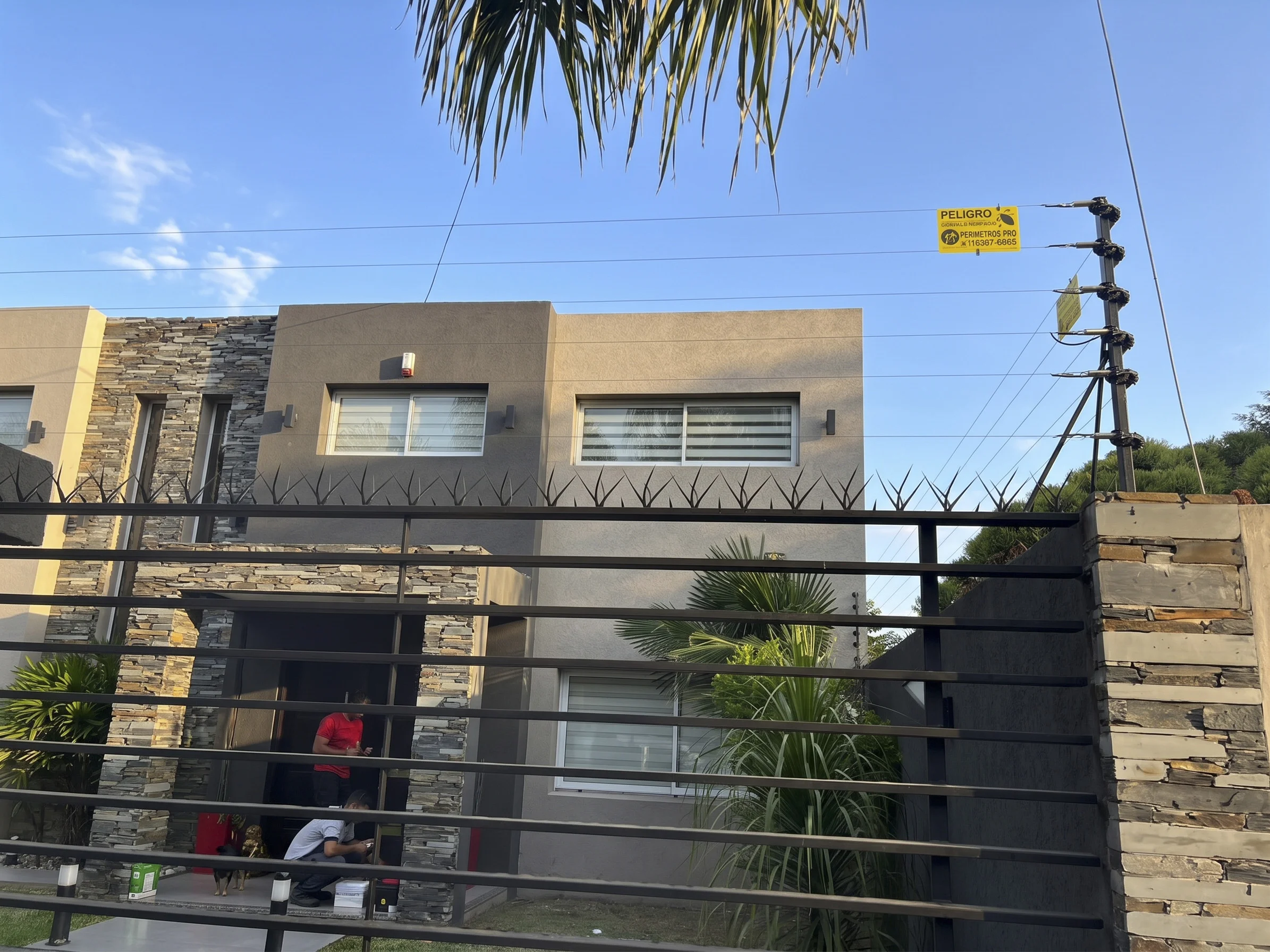 Cerco eléctrico y pinches sobre el frente de una vivienda