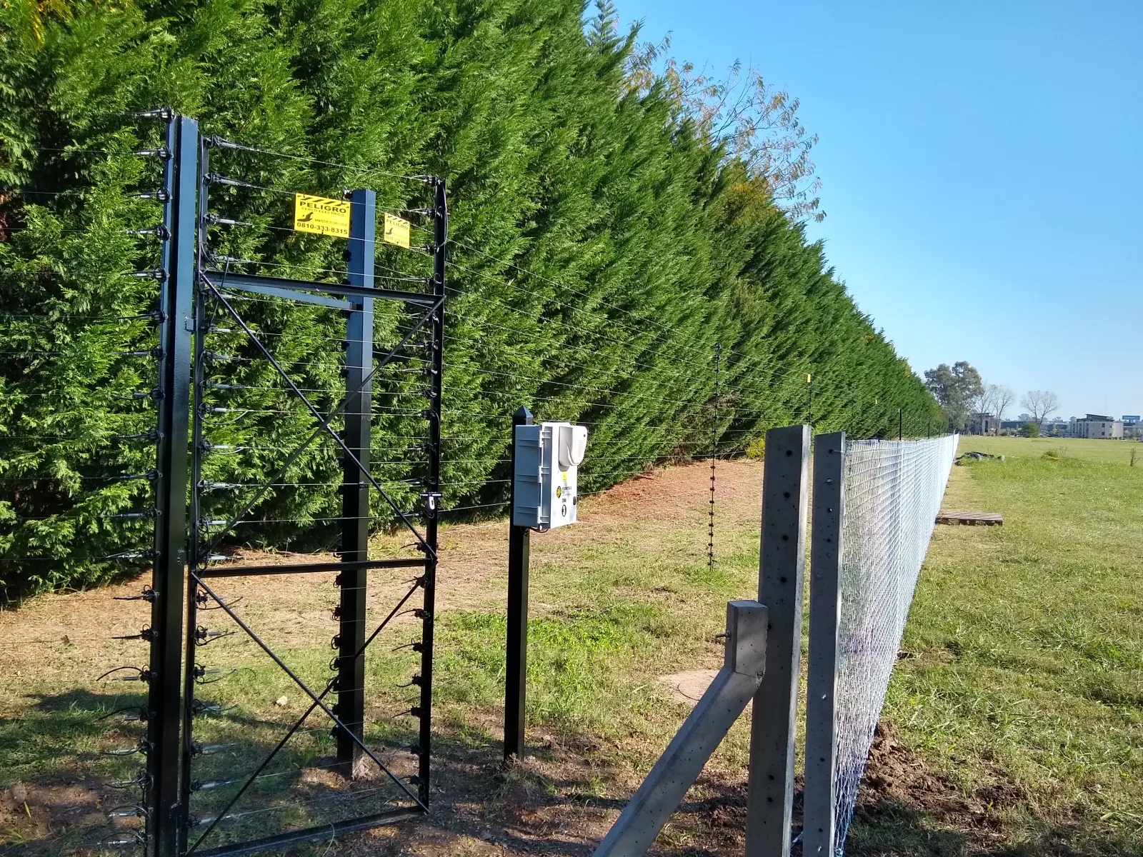 Cerco eléctrico con central sobre el cerco vivo de un barrio privado