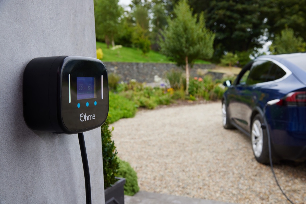 Cargador Ohme instalado en una casa con auto eléctrico en la entrada